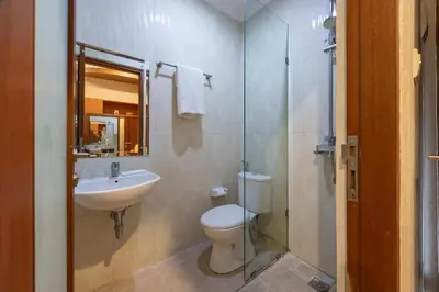 a bathroom with a toilet and a sink and a shower at Cove Vin Stay Petanu in Pesanggaran