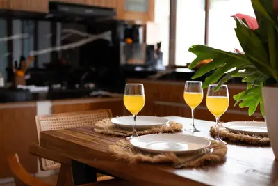a wooden table with three glasses of wine at Villa O'Anne 3 in Seminyak