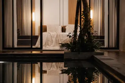 a reflection of a bed in a room with a mirror at Villa Toku by BaliSuperHost in Seminyak