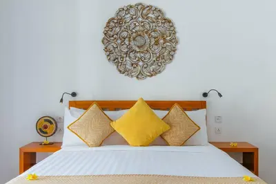 a bedroom with a white bed with yellow pillows at Private 2 Br Pool Villa, 400m to Beach, Sleeps 4 in Seminyak