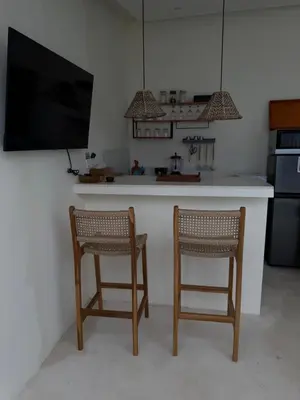 a kitchen with two chairs at a kitchen counter at Villa Bambu in Sanur