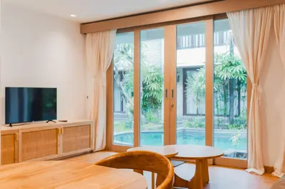 a living room with a table and a large window at Iryla Villa Bali in Seminyak