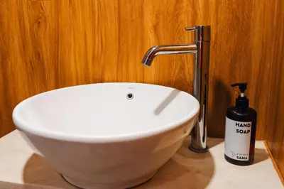 a bathroom with a sink and a bottle of soap at Iryla Villa Bali in Seminyak