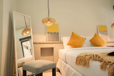 a bedroom with a bed and a chair and a mirror at Kuta Sekeca CoWorking Apartment Close to Kuta Beach in Jimbaran