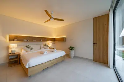 a bedroom with a bed and a ceiling fan at Kona Resort - Seminyak in Kerobokan