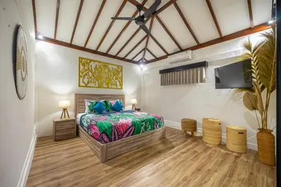 a bedroom with a bed and a flat screen tv at Villa Lebah Seminyak in Seminyak