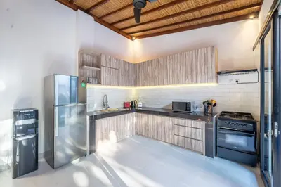 a kitchen with stainless steel appliances and wooden cabinets at Villa Lebah Seminyak in Seminyak