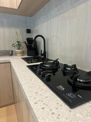 a kitchen counter with a black stove top oven at Villa Vela 6 BR Seminyak in Seminyak