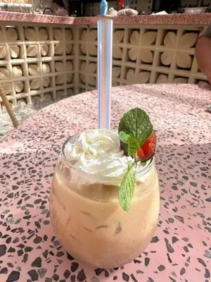 a drink with a strawberry and whipped cream on a table at Villa Vela 6 BR Seminyak in Seminyak