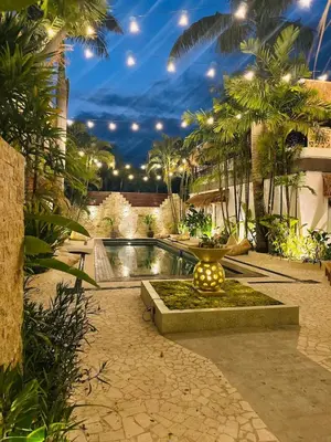 a backyard with a pool and palm trees at Villa Vela 6 BR Seminyak in Seminyak