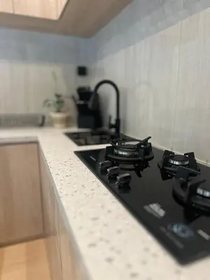 a kitchen counter with a black stove top oven at Villa Vela 6 BR Seminyak in Seminyak
