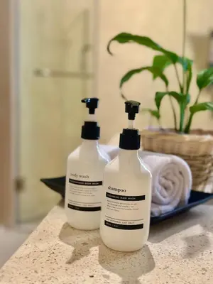 two bottles of laundry detergent sitting on a bathroom counter at Villa Vela 6 BR Seminyak in Seminyak