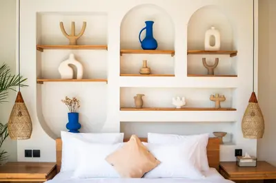 a bedroom with white walls and shelves with blue vases at New Luxury villa walk to Atlas, Finns and Berawa beach in Canggu