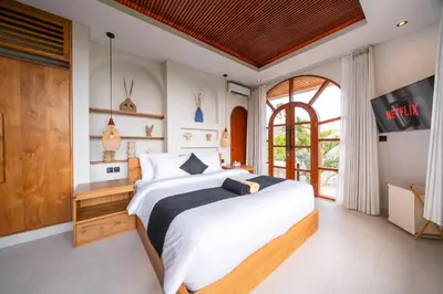 a bedroom with a large bed and a tv at New Luxury villa walk to Atlas, Finns and Berawa beach in Canggu