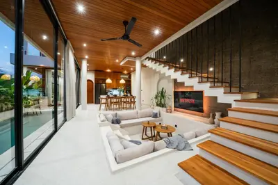 an open living room with a staircase and a fireplace at New Luxury villa walk to Atlas, Finns and Berawa beach in Canggu