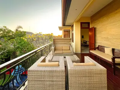a balcony with rattan chairs and a view of the ocean at Villa Michelle Bali in Seminyak