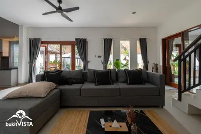 a living room with a couch and a ceiling fan at Serayu Mertanadi by Bukit Vista in Seminyak