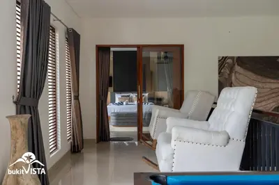 a living room with two white chairs and a bed at Serayu Mertanadi by Bukit Vista in Seminyak