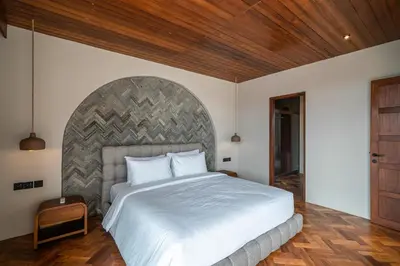 a bedroom with a large bed and a wooden ceiling at Sonaa Villa Bali in Canggu