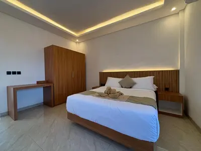 a bedroom with a bed with a teddy bear on it at Taman Sari Guesthouse in Kerobokan