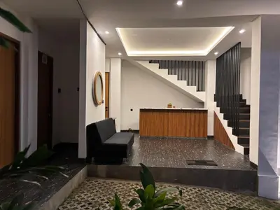 a lobby with a chair and a stair case at Taman Sari Guesthouse in Kerobokan