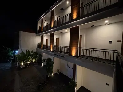 an apartment building at night with its lights on at Taman Sari Guesthouse in Kerobokan
