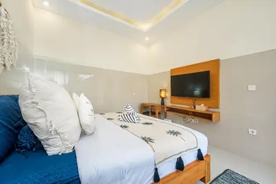 a bedroom with a bed and a flat screen tv at Adikara Villa 2 Cozy 2BR in Canggu, Berawa 5 mins to the beach in Canggu