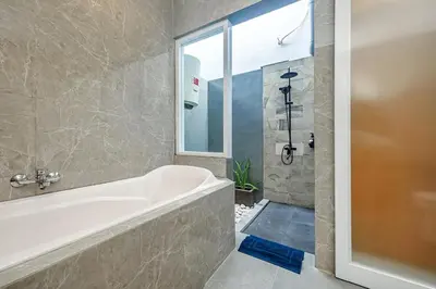 a bathroom with a bath tub and a window at Adikara Villa 2 Cozy 2BR in Canggu, Berawa 5 mins to the beach in Canggu