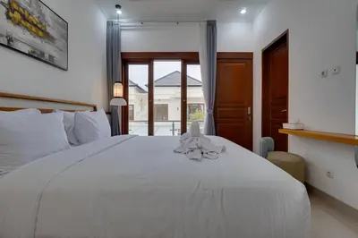 a bedroom with a white bed and a window at Stylish 3BR Villa Palm Haven 11 near Central Seminyak in Seminyak