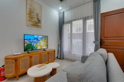 a living room with a couch and a tv at Stylish 3BR Villa Palm Haven 11 near Central Seminyak in Seminyak