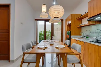 a dining room with a wooden table and chairs at Stylish 3BR Villa Palm Haven 11 near Central Seminyak in Seminyak