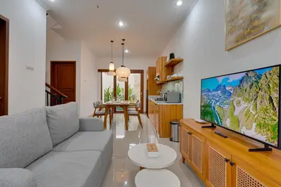 a living room with a couch and a large tv at Stylish 3BR Villa Palm Haven 11 near Central Seminyak in Seminyak