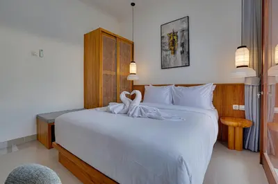 a bedroom with a white bed with a towel on it at Stylish 3BR Villa Palm Haven 11 near Central Seminyak in Seminyak