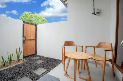 two chairs and a table on a balcony at Abimanyu Guest House in Seminyak