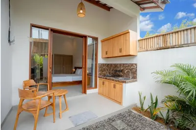 a kitchen and dining area of a house with a bedroom at Abimanyu Guest House in Seminyak
