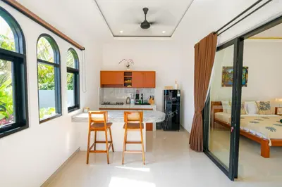a kitchen and living room with a table and chairs at Crystal Flow Guest House & Apartment Canggu in Canggu