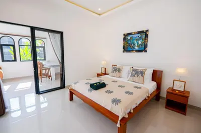 a bedroom with a bed and a table in a room at Crystal Flow Guest House & Apartment Canggu in Canggu