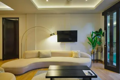 a living room with a couch and a tv on the wall at Luxury Villa 3br 5min to Seminyak beach in Seminyak