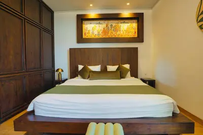 a bedroom with a large bed with a wooden headboard at Luxury Villa 3br 5min to Seminyak beach in Seminyak
