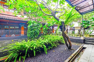 a small tree in a garden in front of a building at Townhouse Oak @lebak Bene Near Kuta Beach in Balian