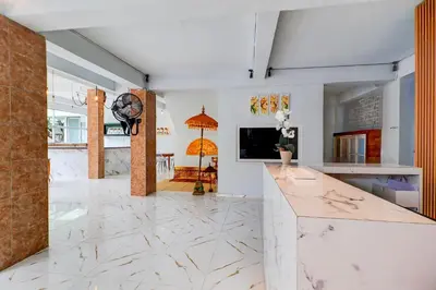 a kitchen with white marble flooring and a tv at Townhouse Oak @lebak Bene Near Kuta Beach in Balian