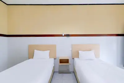 two beds sitting next to each other in a room at Townhouse Oak @lebak Bene Near Kuta Beach in Balian