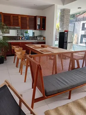 a kitchen with wooden tables and chairs in a kitchen at Villa Diraya 2 Bedroom Villa in Kerobokan in Kerobokan
