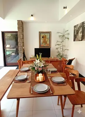 a dining room with a wooden table and chairs at Villa Diraya 2 Bedroom Villa in Kerobokan in Kerobokan