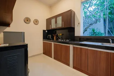 a kitchen with wooden cabinets and a large window at New Villa 50 Seminyak in Seminyak
