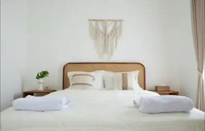 a white bed with two white pillows on it at GB UNLU Villas in Kerobokan