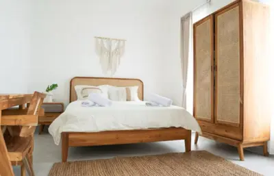 a bedroom with a bed with white sheets and pillows at GB UNLU Villas in Kerobokan