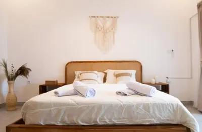 a bedroom with a bed with white sheets and pillows at GB UNLU Villas in Kerobokan