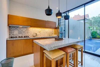 a kitchen with a counter and a large window at Family 3BR Villa Laviosa in Petitenget near Beach in Seminyak