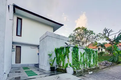 a white house with green ivy on the side of it at Family 3BR Villa Laviosa in Petitenget near Beach in Seminyak